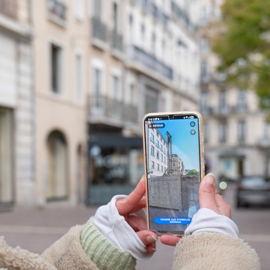 Portable pointant un endroit réel sur lequel une guillotine apparait en 3d